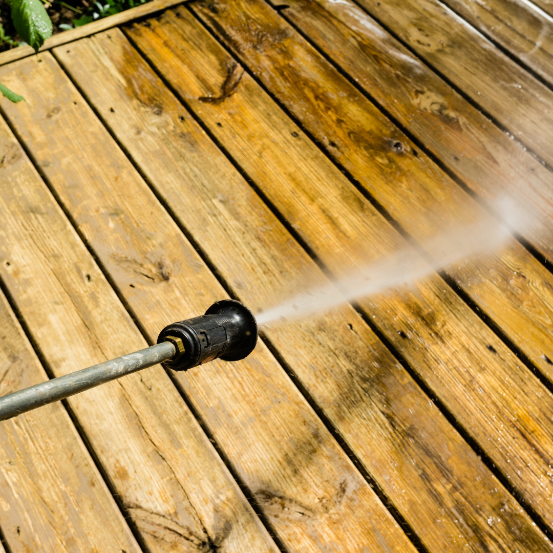 Pressure washing nozzle cleaning wooden pool deck, removing grime and stains for a safer, cleaner outdoor space.