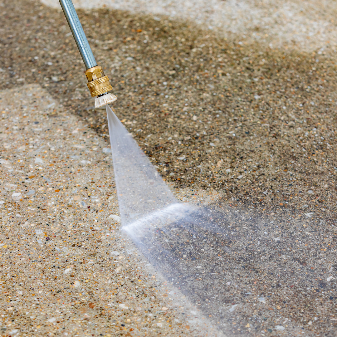 Concrete Cleaning Benefits High-pressure water spray cleaning concrete surface, demonstrating professional concrete cleaning service for stain removal and maintenance.